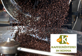 Bild von Kaffeebohnen die aus einem Metalleimer in eine Röstmaschine gekippt werden, mit dem Logo der Kaffeerösterei